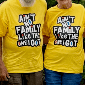 Two people in matching yellow family reunion tees reading Ain't No Family Like The One I Got
