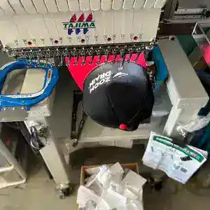 A black Zoom Drain cap on the Tajima embroidery machine part way through a run