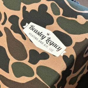 Camouflage apparel carrying a printed Beasley Legacy Heating and Air logo