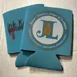 Teal can coolers printed for the Junior Women's League of Smithfield, beside an Ink Kat one