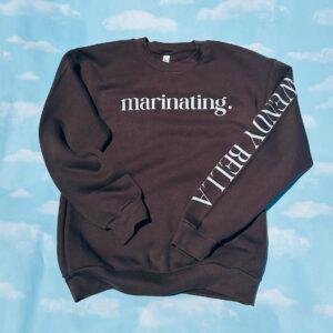 A black marinating crewneck sweatshirt laid flat, with the sleeve lettering visible