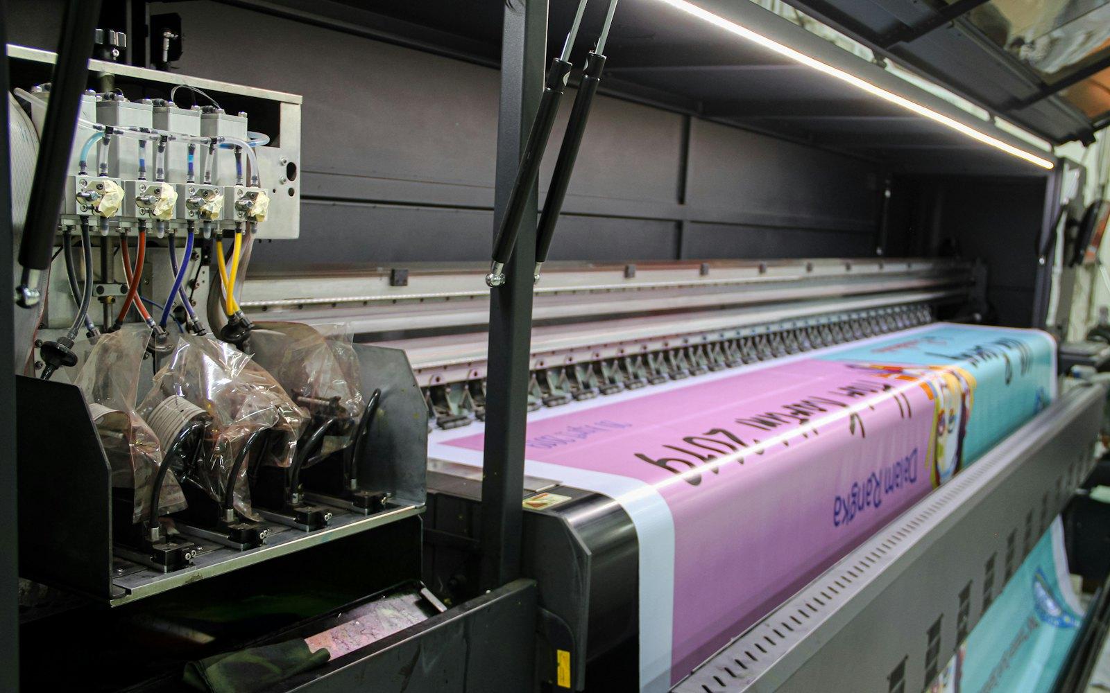 A wide-format printer running a full-colour vinyl banner