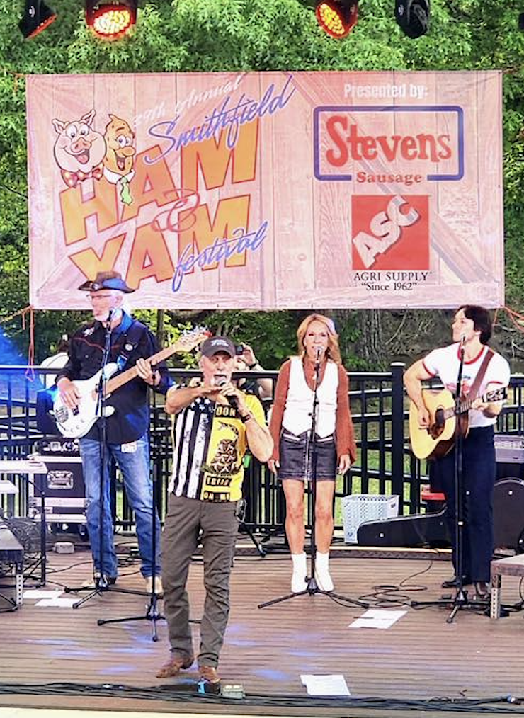 Colorful band performing on stage with microphones and guitars at Ink Kat event.